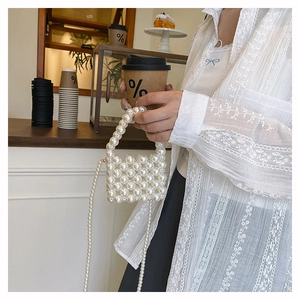 Detail of woven faux pearl mini crossbody bag with top handle and long pearl strap