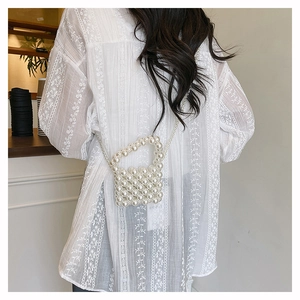 Detailed view of hand-woven pearl mini bag with elegant strap on model back