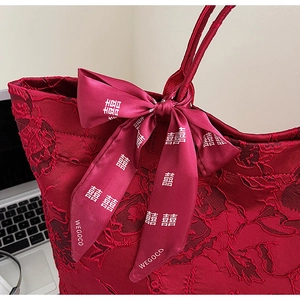 Detail der roten Hochzeitstasche mit besticktem Stoff und Schleife mit dem Symbol Doppel-Xi