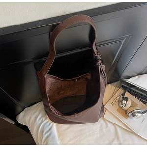 Detail of coffee brown pebble leather shoulder bag with magnetic clasp and wide strap