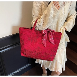 Detail der roten Jacquard-Einkaufstasche mit Vintage-Prägung und dekorativer Bandschleife
