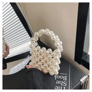 Detailed close-up of a mini white pearl woven handbag with a round beaded top handle