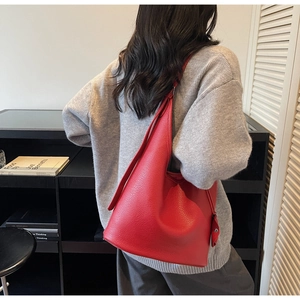 Detailed view of red textured leather hobo bag showing large capacity and soft drape profile