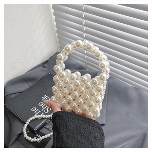 Close-up of a stylish white pearl bead mini bag with a circular handle and chain strap