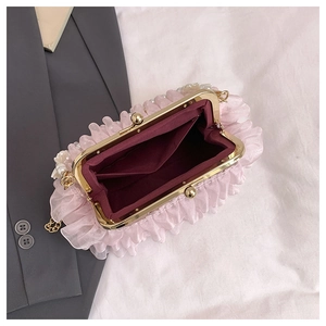 Detail of pink ruffled evening bag with pearl chain strap and red satin interior