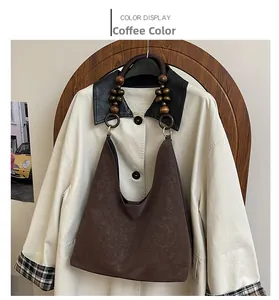 Détail du sac hobo marron café avec des perles en bois rétro sur la bandoulière