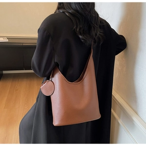Close-up of caramel brown hobo bag featuring litchi grain leather and a round coin purse