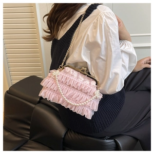 Detailed shot of pink lace ruffled clutch bag with pearl beads and bow decoration