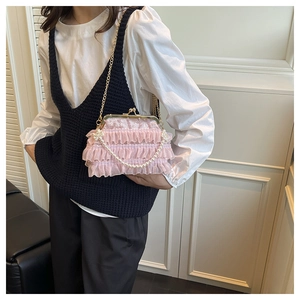 Detail of pink lace pleated handbag featuring a pearl handle and vintage metal clasp