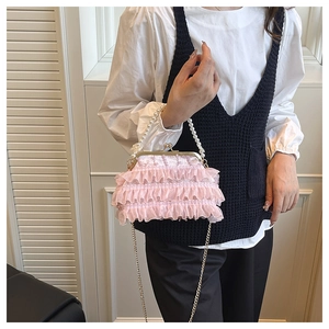 Detail view of pink tulle ruffle bag with white pearl handle and gold metal frame