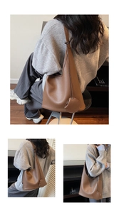 Close-up of brown pebbled leather hobo bag with wide shoulder strap and round charm