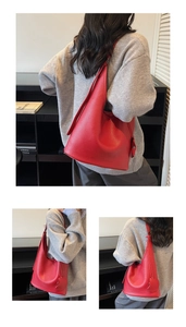 Macro detail of red litchi grain leather hobo bag with matching circular bag charm pendant