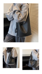 Close-up of black lychee texture leather hobo bag with round charm and shoulder strap