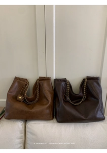 Détails de cabas en cuir vintage avec bandoulières en chaîne dorée et logo embossé