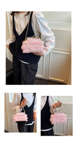 Detail showing the layered pink lace ruffles, pearl handle and gold metal chain strap
