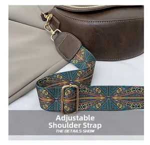 Close-up of adjustable vintage jacquard strap with metal buckle on a brown saddle bag
