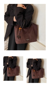 Détail d'un sac cabas en daim marron foncé avec pompon perlé rétro et étiquette