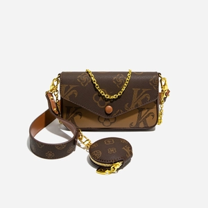 Detail view of brown monogram crossbody bag with gold chain and matching round coin purse