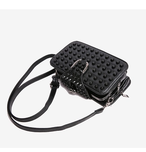 Détail du sac à bandoulière en similicuir noir avec clous punk et doubles fermetures éclair