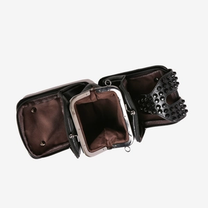 Détail d'un sac bandoulière noir en cuir avec des rivets et des compartiments multiples