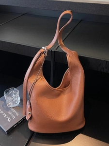 Brown lychee grain leather bucket bag with adjustable shoulder strap and silver hardware