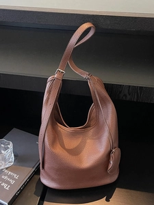 Brown lychee leather hobo bucket bag with adjustable strap and small round pouch