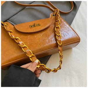 Close-up of caramel brown quilted chain bag with vintage gold clasp and wrinkled leather