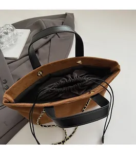 Detail showing inner drawstring lining and brown faux suede texture of the tote bag