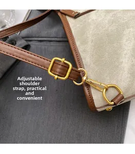 Détail de la bandoulière réglable en cuir marron avec boucle dorée sur sac à dos en toile