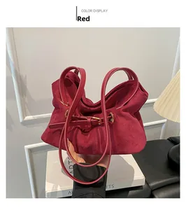 Dettaglio della borsa tote in pelle scamosciata rossa con pieghe morbide e occhielli dorati
