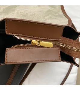 Vue détaillée de la fermeture éclair en métal doré et du tissu texturé vert du sac à dos