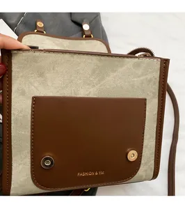 Détail du fermoir magnétique d'un sac bandoulière en toile vintage avec finitions cuir