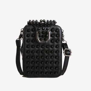 Sac bandoulière punk noir avec rivets métalliques et boucle en U sur fond blanc neutre