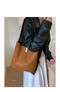 Brown suede bucket bag with gold lock shown on model for daily commuting style