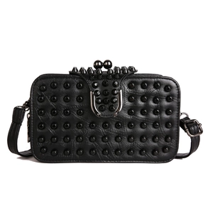 Sac bandoulière noir mat avec clous et fermoir boule métallique au style tendance