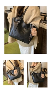 Detail der schwarzen Tote-Bag aus Kunstleder mit dünnen Trägern und Plüschbär-Anhänger