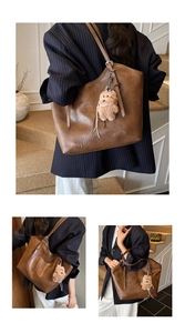 Detail der braunen Vintage-Einkaufstasche mit weichem Leder und Plüschbär-Anhänger