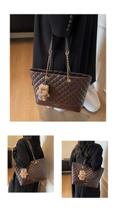 Detail of dark coffee quilted tote bag with gold chain strap and plush bear charm