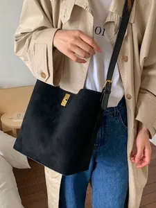 Black frosted leather bucket bag with gold buckle shown on model for daily commuting
