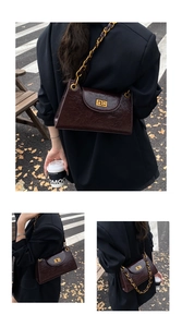 Detail of dark brown vintage oil wax leather bag with gold chain and turn-lock closure