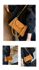 Detail of vintage brown textured underarm bag with gold chain and metal twist lock