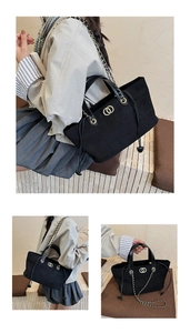 Detail view of black faux suede tote bag with gold metal rings and leather chain strap