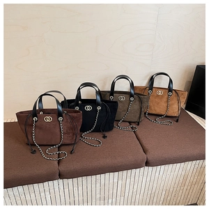 Detail view of four faux suede tote bags in coffee, black, olive and camel colors