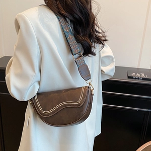 Brown leather saddle bag with beaded trim and ethnic embroidered wide strap