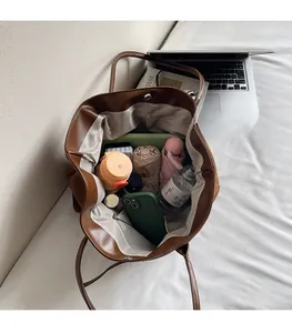 Interior view showing the large storage capacity of the brown faux leather tote bag
