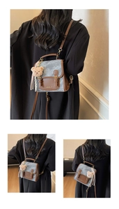 Vue détaillée du mini sac à dos vintage avec bordure en cuir marron et breloque ours
