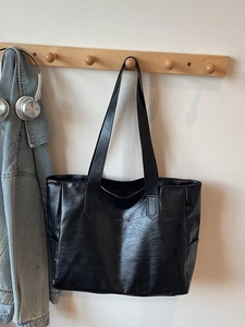 Minimalist black PU leather tote bag with MOOBAG logo and versatile shoulder strap