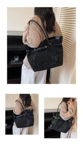 Detail view of large matte black tote bag with strap buckle and slim leather shoulder straps