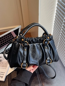 Modern black pleated cloud bag with vintage gold rings and a detachable shoulder strap