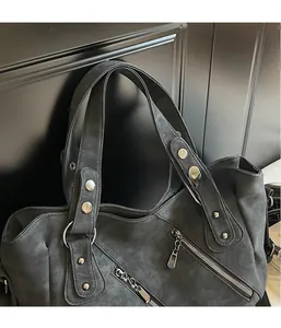 Detail view of charcoal gray vintage matte tote bag with silver studs and zippers